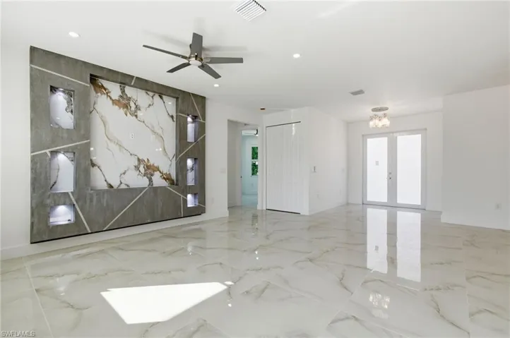 Spare room featuring light marble finish flooring, french doors, ceiling fan, and recessed lighting
