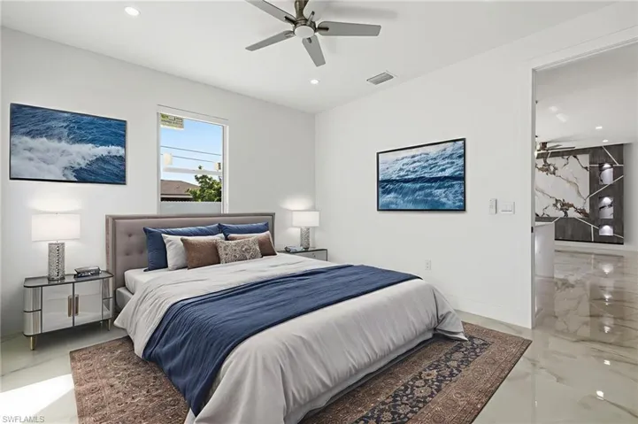 Bedroom with ceiling fan, recessed lighting, and light marble finish flooring