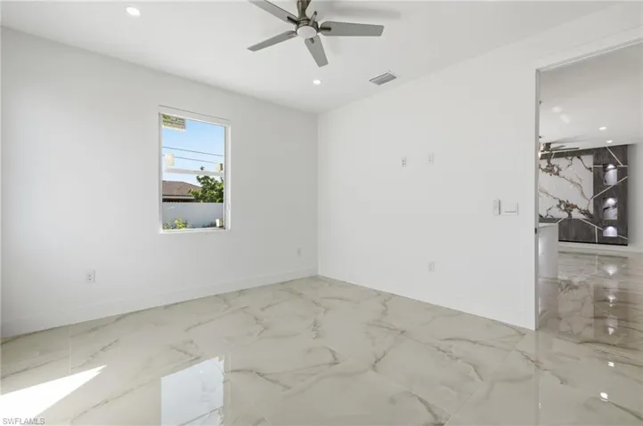 Spare room with ceiling fan, light marble finish flooring, and recessed lighting
