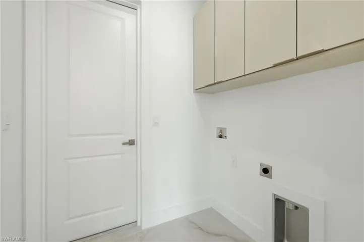 Washroom with light marble finish floors, cabinet space, electric dryer hookup, and washer hookup