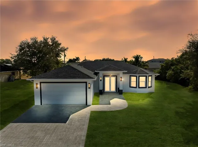 Single story home with a front lawn, driveway, stucco siding, a garage, and roof with shingles