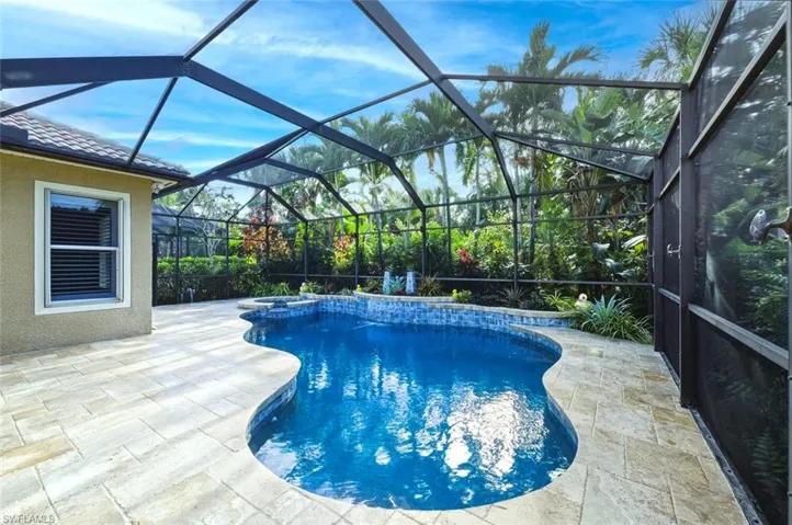 View of swimming pool featuring a sunroom, a lanai, a patio area, and a pool with connected hot tub