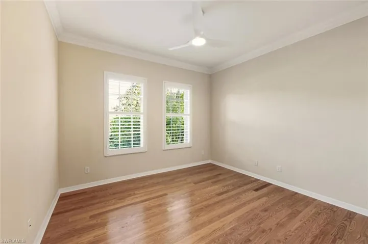 Spare room featuring ornamental molding, wood finished floors, and ceiling fan