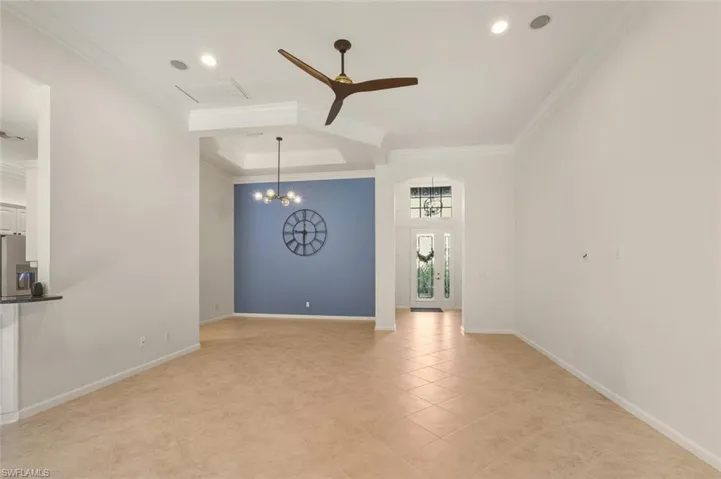 Empty room with a chandelier, ceiling fan, recessed lighting, and light tile patterned floors