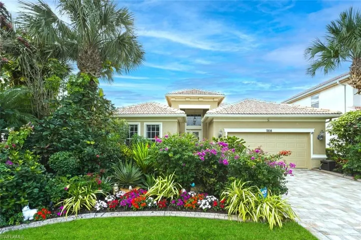 Mediterranean / spanish-style home with stucco siding, a tiled roof, a garage, and driveway