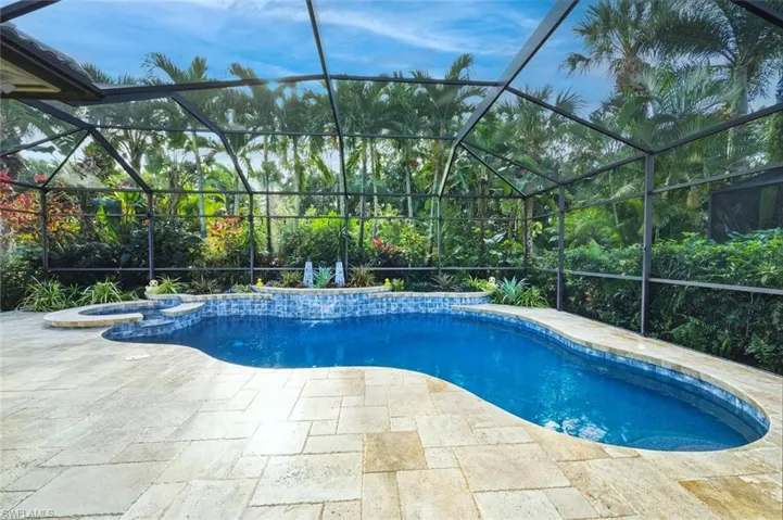 View of swimming pool with a lanai, a sunroom, and a pool with connected hot tub