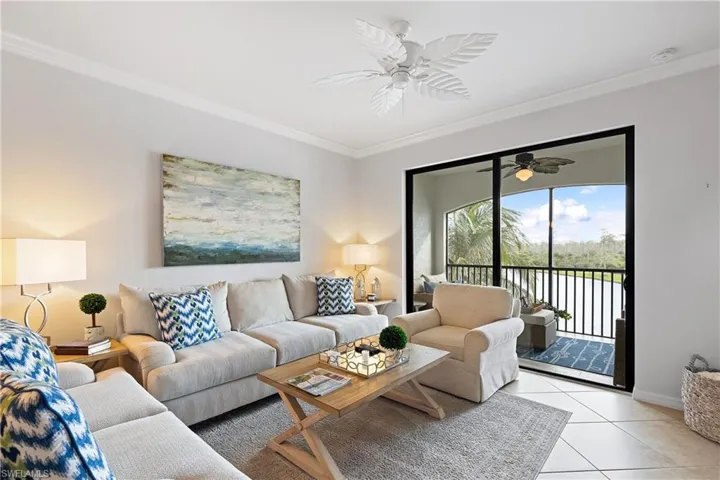 Tiled living room with ceiling fan and crown molding