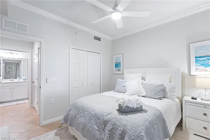 Bedroom featuring ornamental molding, ceiling fan, sink, light tile patterned floors, and a closet