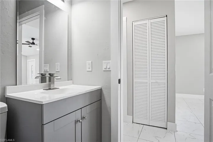 Bathroom vanity with a white countertop and a modern chrome faucet