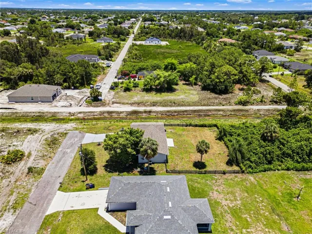 Aerial perspective showcasing multiple properties and expansive undeveloped land