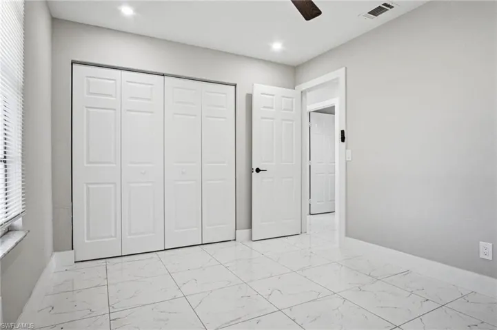 Room featuring light gray walls, large format tile flooring, and recessed lighting
