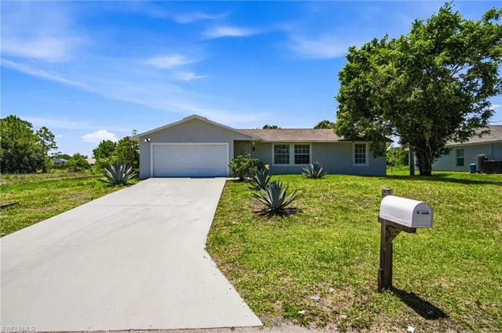 Contemporary stucco exterior with a single-car garage, concrete driveway, and established landscaping