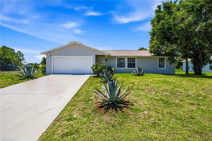 Single-story home featuring a stucco exterior, attached garage, and concrete driveway