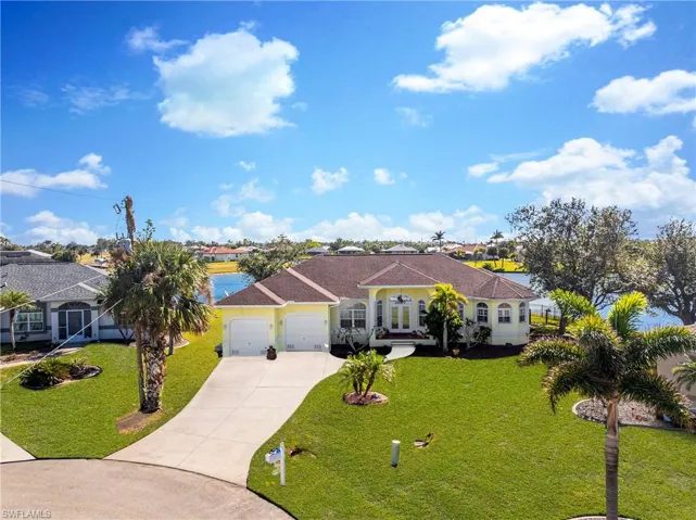 Mediterranean / spanish house featuring driveway, an attached garage, a front lawn, and french doors