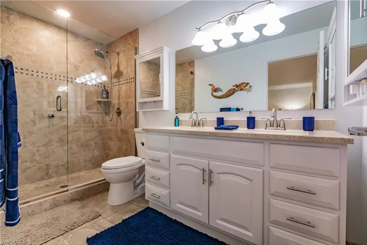 Bathroom featuring vanity, toilet, and a shower with shower door