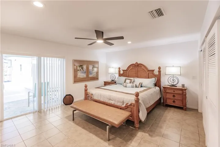 Tiled bedroom with access to exterior, a closet, and ceiling fan