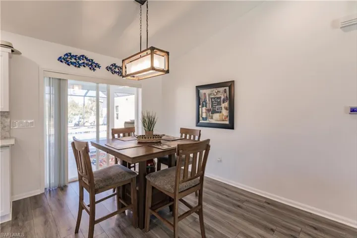 Dining area featuring dark hardwood / wood-style floors and vaulted ceiling