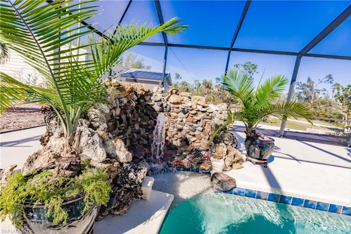 View of swimming pool featuring glass enclosure