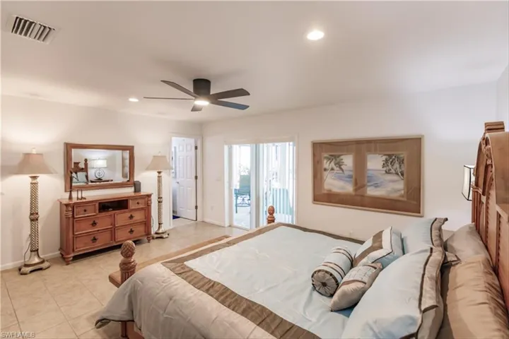 Bedroom with access to exterior, light tile patterned floors, and ceiling fan