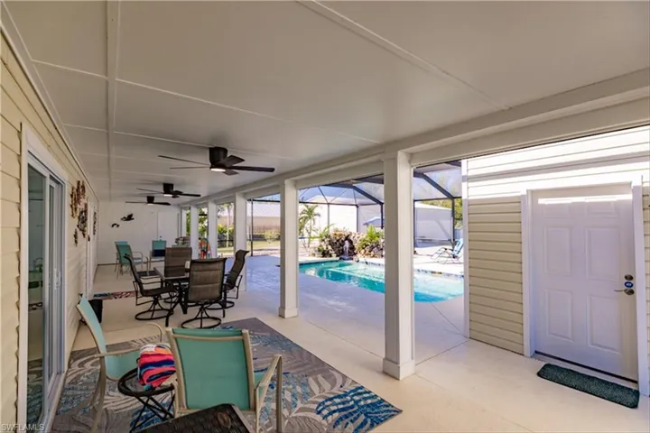 View of patio featuring glass enclosure and ceiling fan