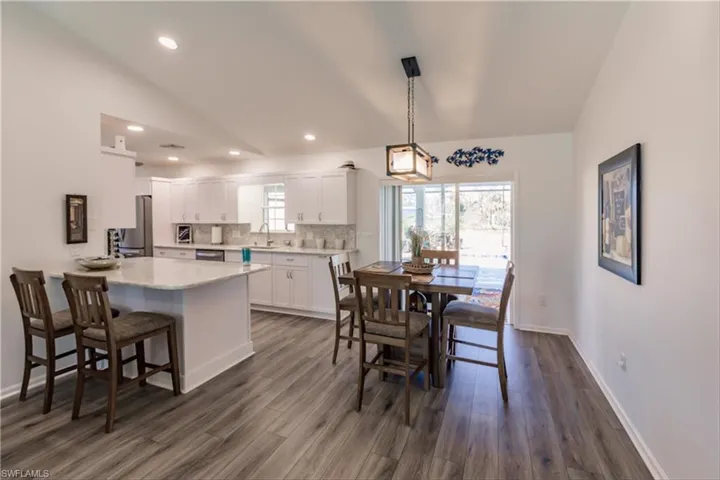 Dining space featuring dark hardwood / wood-style floors, sink, and vaulted ceiling