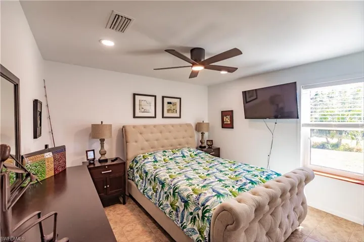 Tiled bedroom featuring ceiling fan
