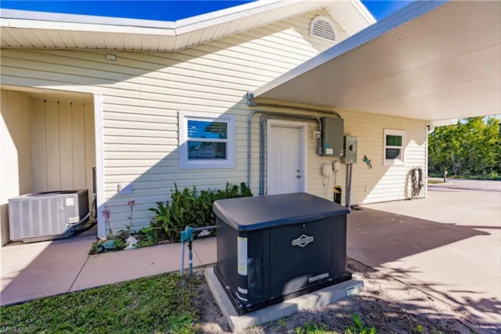 View of patio with a carport and central AC unit