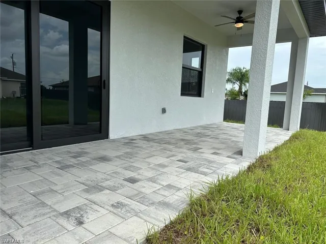 View of patio with fence and a ceiling fan