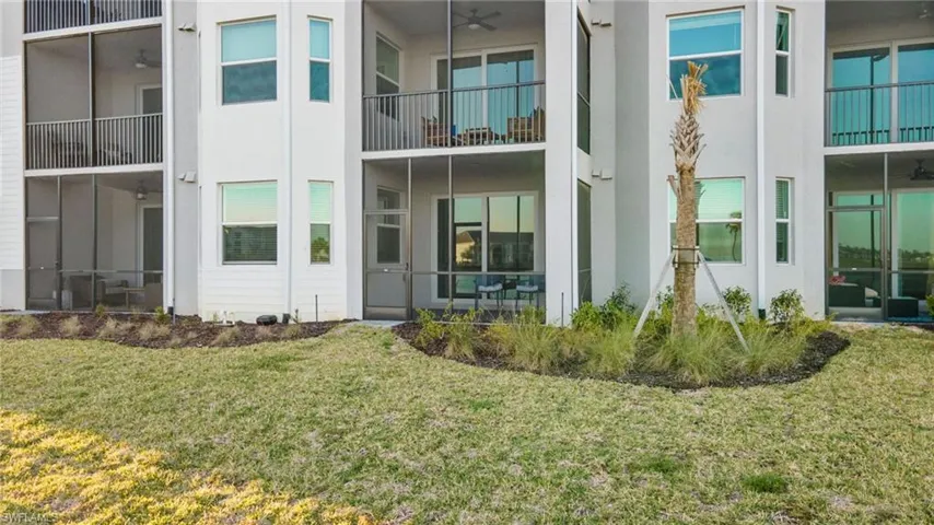 Rear view of house with a balcony and a yard