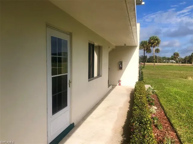 View of property exterior with stucco siding, a yard, and a patio area