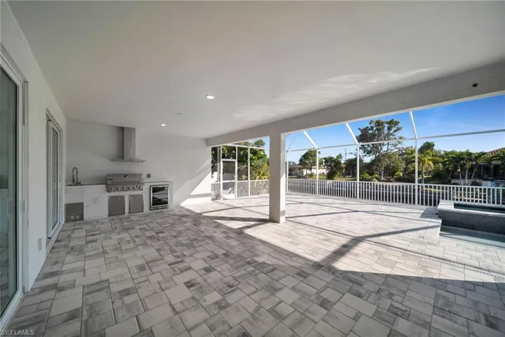 View of patio featuring area for grilling, a sunroom, a lanai, and beverage cooler