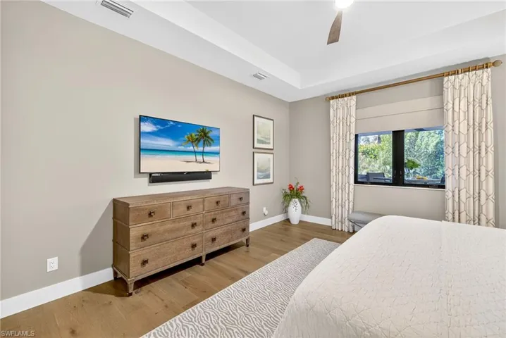 Bedroom with custom window treatments and blackout shade and ceiling fan