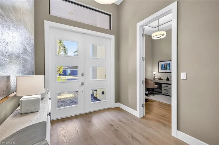 Foyer featuring Mohawk engineered wood finished floors and upgraded double door front entry and french door entry into the den of 4th bedroom
