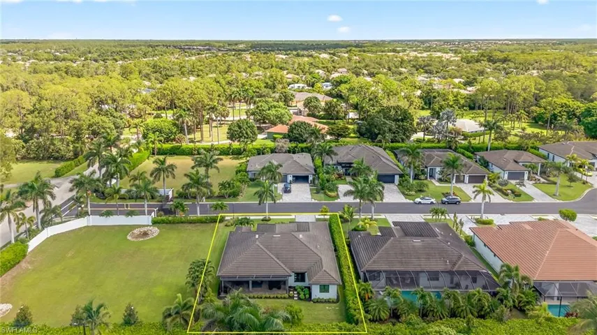 Aerial view of residential area featuring property boundaries highlighted and open neighboring lot basin