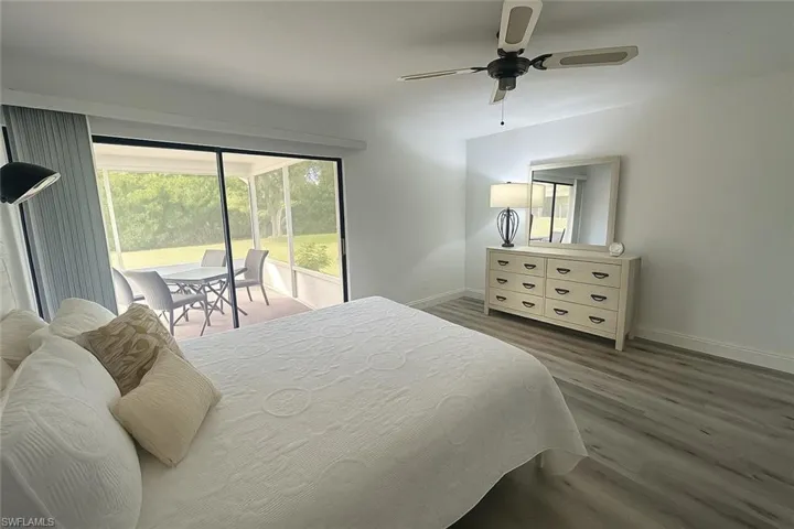 Bedroom with access to outside, dark wood-style flooring, and a ceiling fan