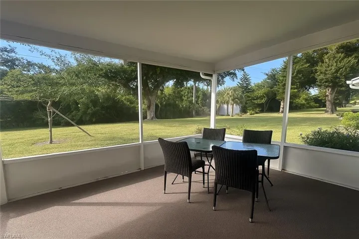 Sunroom with outdoor dining space, plenty of natural light, and view of scattered trees