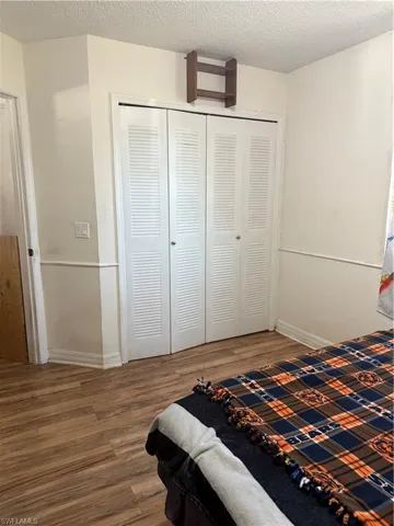 Bedroom featuring a textured ceiling and wood finished floors