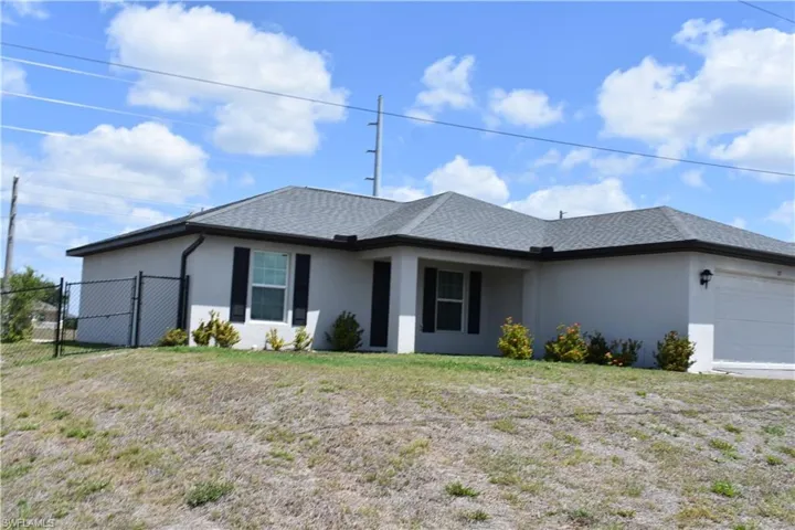 View of front of house with a gate, roof with shingles, stucco siding, fence, and an attached garage