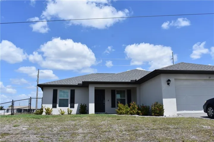 View of front of property with fence, a garage, a front lawn, stucco siding, and a shingled roof