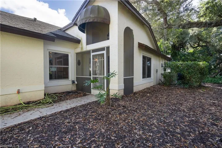 View of side of home featuring stucco siding and a shingled roof