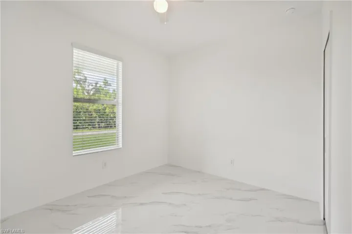 Unfurnished room featuring ceiling fan and a healthy amount of sunlight