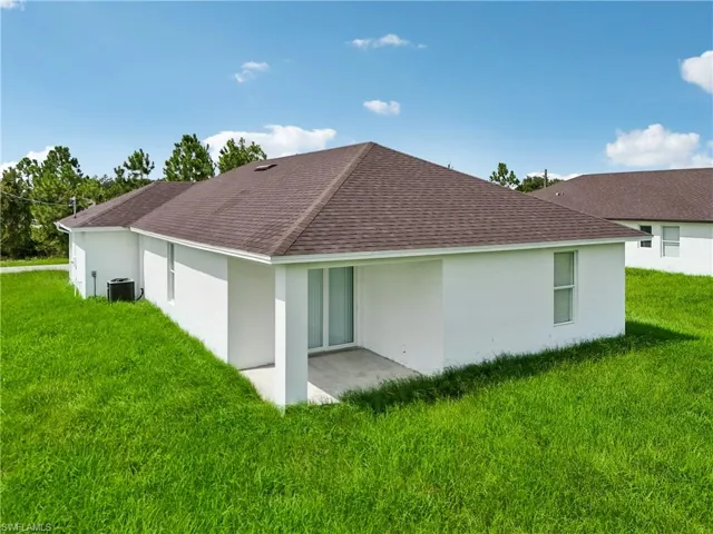 Back of property featuring cooling unit, a yard, and a patio area