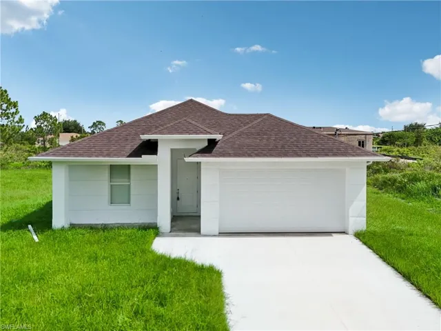 Single story home featuring a garage and a front yard