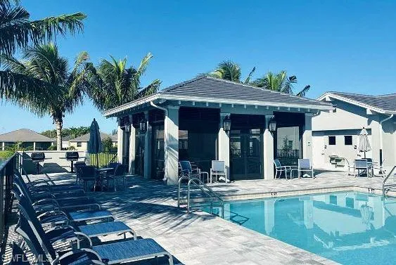Community pool with a patio area and an outdoor structure