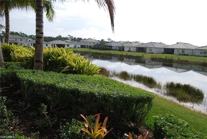 Community pond view featuring nearby suburban area
