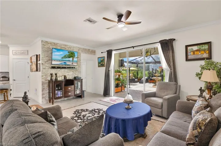Living room with a ceiling fan and ornamental molding