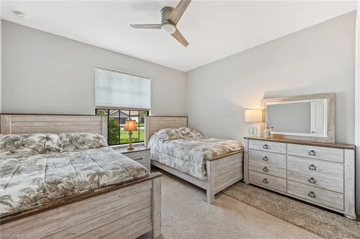Bedroom with ceiling fan and light carpet