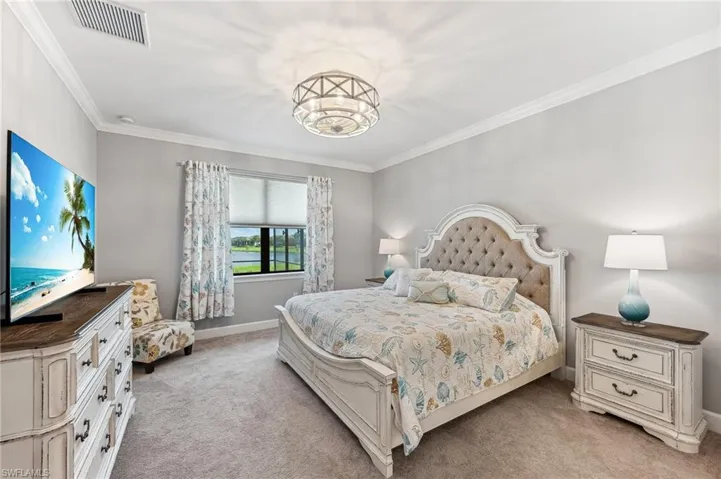 Carpeted bedroom featuring crown molding