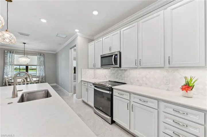 Kitchen featuring white cabinetry, stainless steel appliances, sink, and decorative backsplash