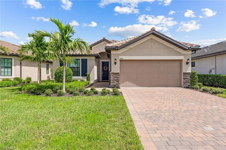 View of front of property featuring a front yard and a garage